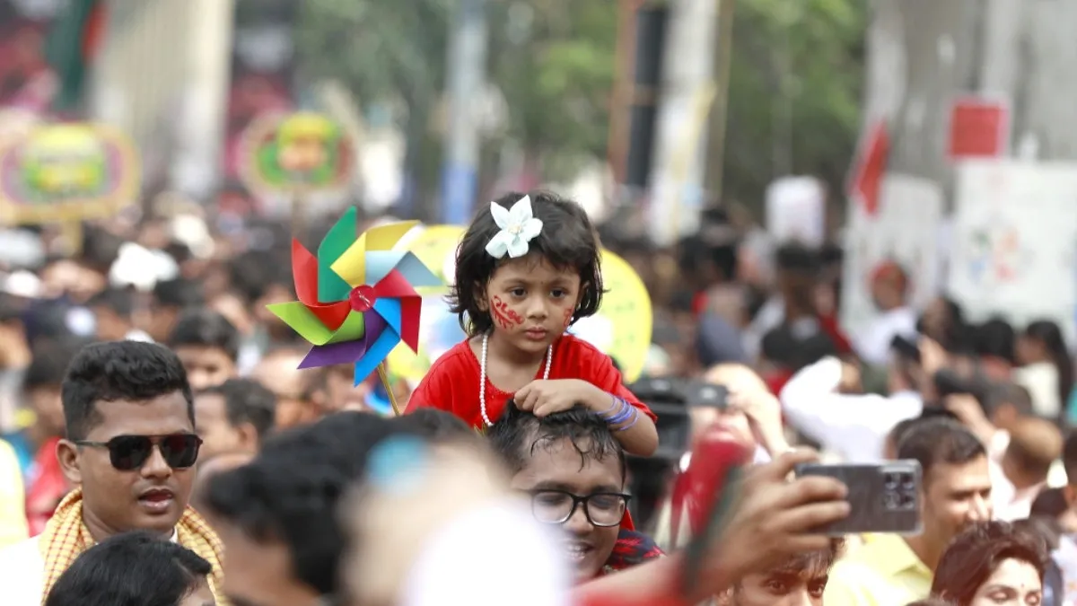 বাবার কাঁধে চড়ে বৈশাখী শোভাযাত্রায় অংশ নিতে এসেছে ছোট্ট শিশুটি