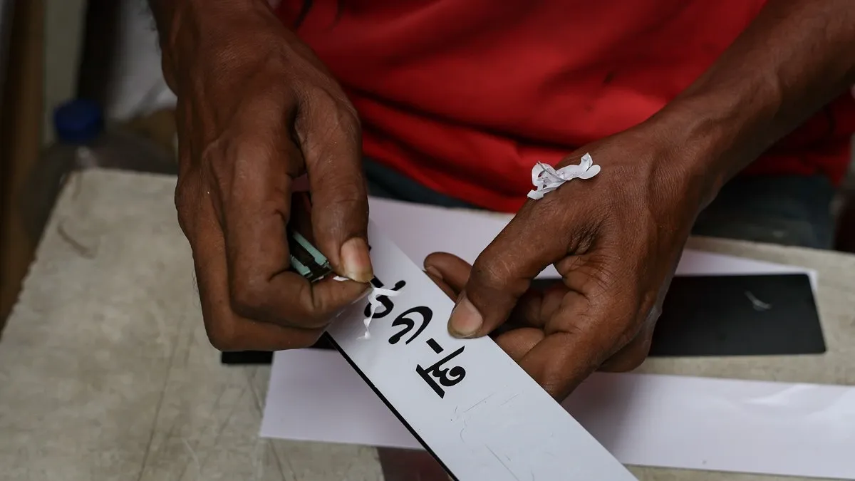 নাম্বার প্লেটে স্টিকার লাগানো হচ্ছে