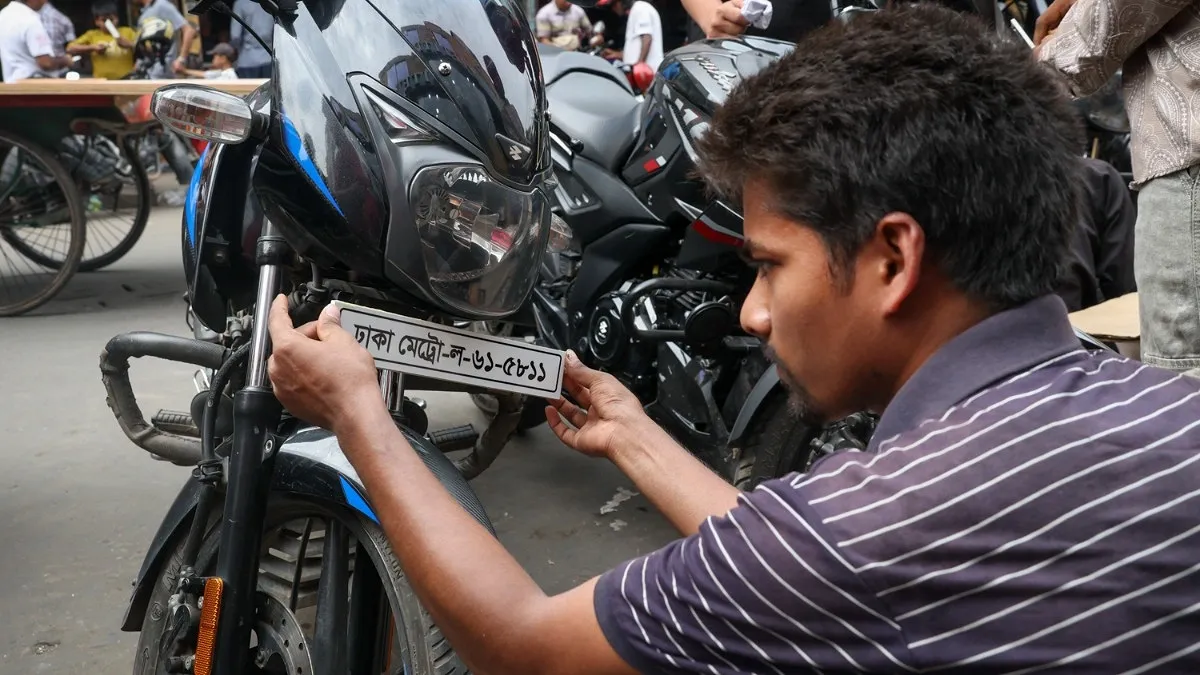 মোটরসাইকেলের সামনের অংশে সংযোজন করা হচ্ছে নাম্বার প্লেট